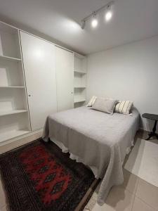 Habitación blanca con cama y alfombra en Depto nuevo zona Alto Rosario en Rosario