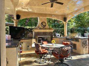 un patio al aire libre con mesa y chimenea en Tuscany Dorado Resort en Cameron Park