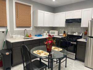 a kitchen with a small table and a kitchen with white cabinets at Cozy Getaway Room in Newark