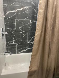 a bathroom with a shower curtain next to a bath tub at Cozy Getaway Room in Newark