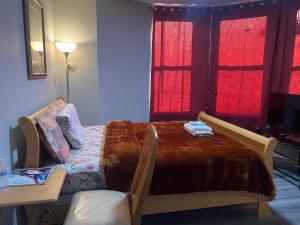 a bedroom with a bed and a table and windows at Cozy Getaway Room in Newark