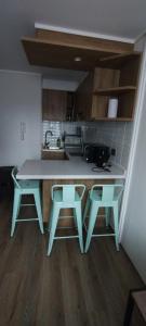 a kitchen with a table and two stools at Hermoso y cómodo departamento in Santiago