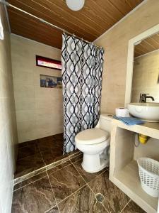 a bathroom with a toilet and a sink at CASA DE CAMPO CASTILLETE dentro del PARQUE TAYRONA in Santa Marta