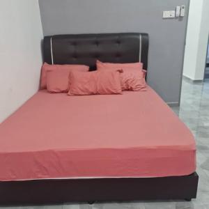 ein großes Bett mit rosa Bettwäsche und rosa Kissen in der Unterkunft Homestay Kuala Dungun in Dungun