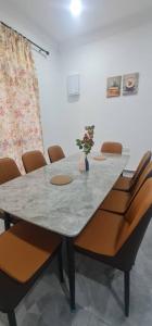 a table with chairs and a vase with flowers on it at Homestay Kuala Dungun in Dungun +13 photos