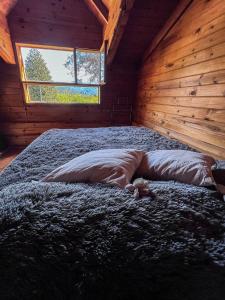 een persoon op een bed in een kamer met een raam bij Casa Buena Vista in Bariloche