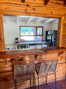a wooden bar with two chairs in a room at Casa Buena Vista in San Carlos de Bariloche