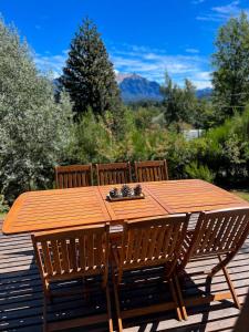 a wooden table with four chairs on a deck at Casa Buena Vista in San Carlos de Bariloche