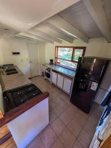 a kitchen with a black refrigerator and a counter at Casa Buena Vista in San Carlos de Bariloche