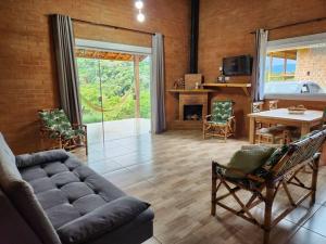 a living room with a couch and a fireplace at Casa Da Floresta Cercada com Piscina in Santo Antônio do Pinhal