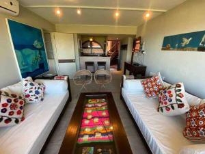 a living room with a couch and pillows at Apartamento Terrazas de Manantiales frente al mar in Punta del Este