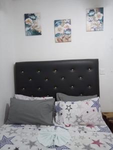 a bed with a black headboard and some pillows at Chic Vybz Deluxe in Four Mile