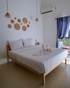 łóżko w sypialni z pieczeniami na ścianie w obiekcie The Canopy Krabi w Aonang Beach
