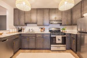 a kitchen with wooden cabinets and stainless steel appliances at Designer Apt for 6, City Views, near Times Square! in New York