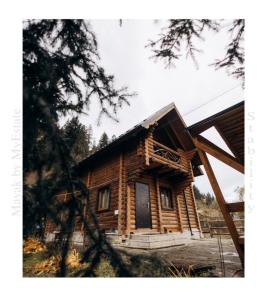 uma cabana de madeira com um alpendre e uma porta em Mayak Chalet Resort Mykulychyn em Mykulychyn