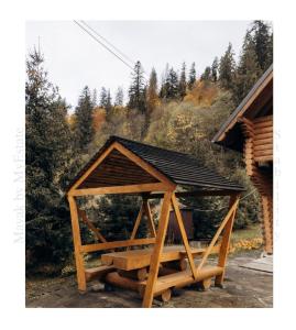 drewniana altana siedząca obok domu w obiekcie Mayak Chalet Resort Mykulychyn w mieście Mikuliczyn
