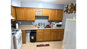 a small kitchen with wooden cabinets and a sink at Glamour Room C 6mins to Newark Liberty International Airport and 3mins to Near Penn Station in Newark