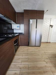 a kitchen with a refrigerator and a tile floor at Departamento Céntrico y Moderno in Santiago