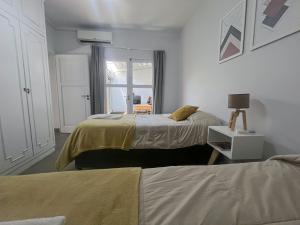 a bedroom with two beds and a window at Hermosa casa estilo nórdico en tranquilo barrio céntrico in Mendoza +22 photos