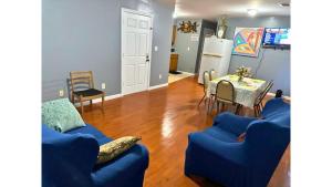 una sala de estar con 2 sofás azules y una mesa. en Divine GUEST HOUSE Room B 6MINS TO NEAR Newark Liberty International Airport AND 4 MINS To Penn Station Prudential, en Newark