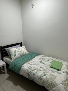 クアラ・セランゴールにあるRafahiyyah Homestay, Puncak Alamのベッドルーム1室(緑の毛布と枕付きのベッド1台付)