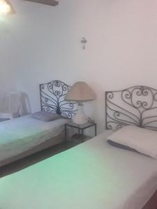 Ticumán的住宿－Casita en Ticuman，一间卧室设有两张床和一张桌子上的台灯。