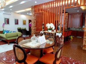 a living room with a table and chairs and a couch at PMG Islandscape Resort in Siquijor