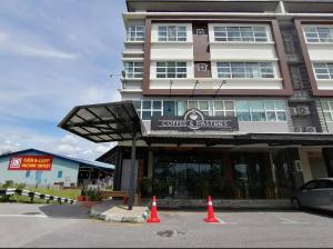 un edificio con conos de tráfico naranja delante de él en The Executive Apartment @ Kuching City Mall, en Kuching