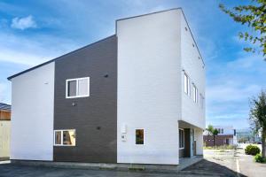 a house with a black and white facade at FuranoSky - Blue in Furano