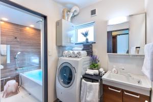 a bathroom with a washing machine and a sink at FuranoSky - Blue in Furano +71 photos