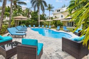 a resort pool with blue chairs and umbrellas at Paradise Six in Creek Village