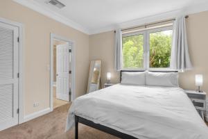 a white bedroom with a large bed and a window at Paradise Six in Creek Village
