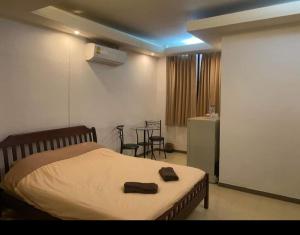 Un dormitorio con una cama y una mesa y sillas. en jomtien seaside guesthouse, en Jomtien Beach