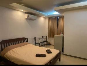 Un dormitorio con una cama y una mesa y sillas. en jomtien seaside guesthouse, en Jomtien Beach 8 fotos más