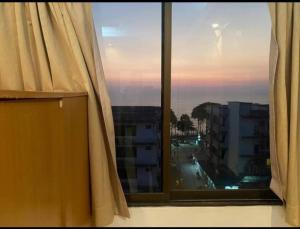 a window with a view of a city at jomtien seaside guesthouse in Jomtien Beach