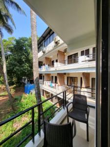 a balcony view of a resort with two chairs at hotel ramdev in Arambol