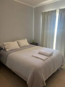 a bedroom with a large bed with two towels on it at Departamento céntrico en Lobos in Lobos