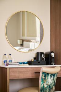 a mirror on a desk with a sink and a chair at The James Hotel in Tralee