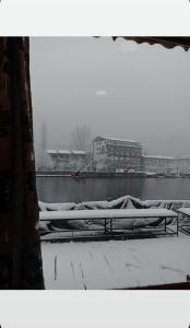 a window with a snow covered bench next to a body of water at Hb nancy group of houseboats in Srinagar