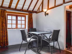 einen Tisch und Stühle in einem Zimmer mit Fenster in der Unterkunft Barn Suite in Beaconsfield