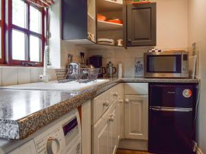 a kitchen with a sink and a microwave at Barn Suite in Beaconsfield