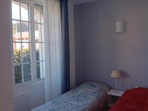 um quarto com uma cama ao lado de uma janela em Appartement Hendaye, 3 pièces, 6 personnes - FR-1-239-1018 em Hendaye