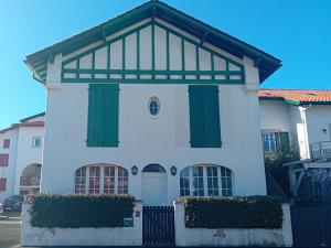 uma casa branca com portas verdes e um portão em Appartement Hendaye, 3 pièces, 6 personnes - FR-1-239-1018 em Hendaye