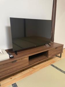 telewizor z płaskim ekranem w drewnianym centrum rozrywki w obiekcie SEA&SEE KOSE w mieście Kose