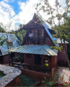 a man standing on the balcony of a house at El campo en Jarabacoa in Jarabacoa