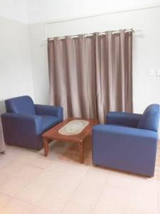 two blue chairs and a coffee table in a room at Lelago Eco Lodge in Apia