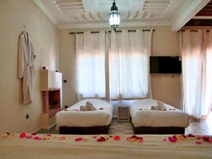two beds in a room with flowers on the floor at Whisper in Marrakech