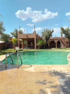 a swimming pool in front of a house at Whisper in Marrakesh