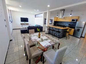 a kitchen and a living room with a table and chairs at Departamento Nuevo Suite Máster in Aguascalientes