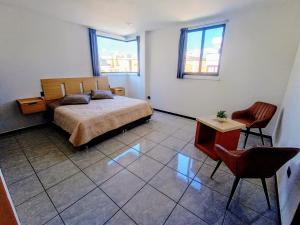 アグアスカリエンテスにあるDepartamento Nuevo Suite Másterのベッドルーム1室(ベッド1台、テーブル、椅子付)